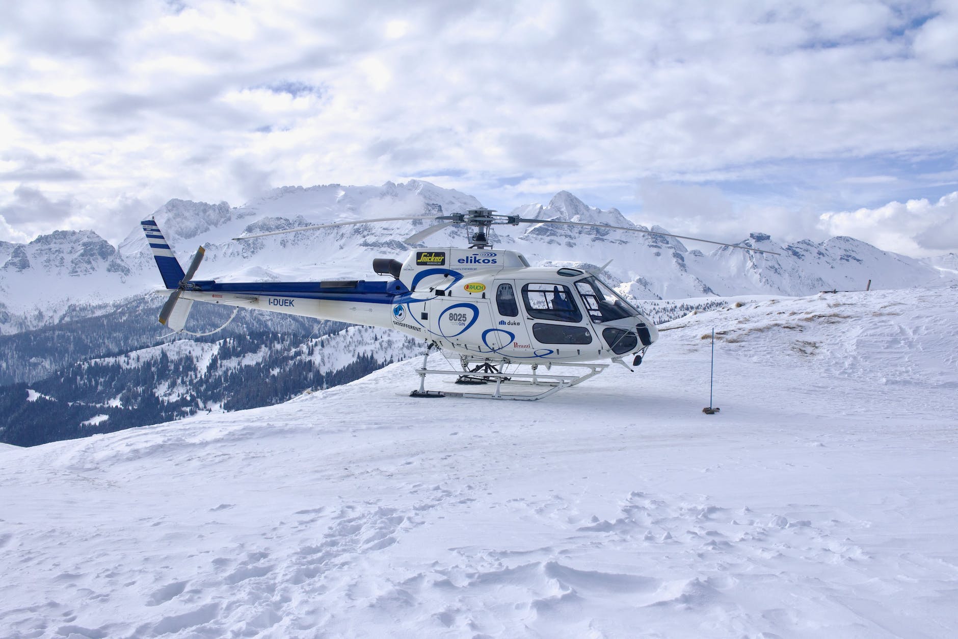 white and blue helicopter on snow covered ground